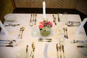 a table with a white table cloth with a vase of flowers at Hotel Vierjahreszeiten in Flachau