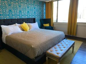 - une chambre avec un lit et un banc dans l'établissement The Village Inn Hotel, à Milwaukee