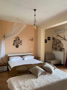 een slaapkamer met een groot bed en een bank bij Guesthouse Kerkinitis in Lithótopos