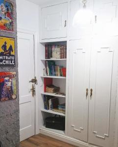 een kamer met een witte kast met boeken bij Apartamento boutique "A casa de Lola" in Boiro