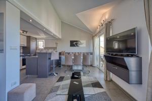 a large living room with a tv and a kitchen at Porto View Three-Bedroom Duplex in Tivat