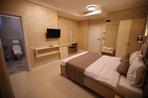 a bedroom with a bed and a bathroom with a toilet at Hotel Grand Dedal in Mamaia Nord
