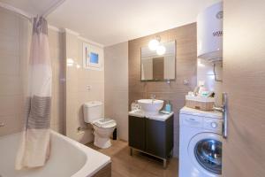W łazience znajduje się toaleta z umywalką i pralka. w obiekcie Stratos & Magda's Apartments w mieście Neos Marmaras +15 zdjęć