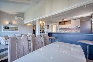 a dining room with a white table and chairs at Porto View Three-Bedroom Duplex in Tivat