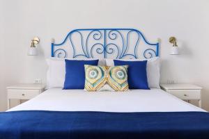 a blue and white bed with blue and white pillows at Volver B&B in Gaeta