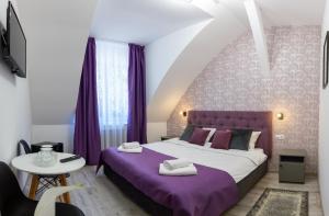 - une chambre avec un lit violet et une couverture violette dans l'établissement Hotel Amel Rooms, à Mediaş