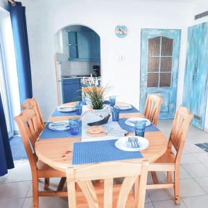 einem Holztisch mit Stühlen und einem blauen Tischtuch in der Unterkunft Lake House20 in Velence
