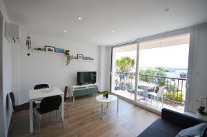 sala de estar con mesa y ventana grande en Golive De Mar en Cambrils