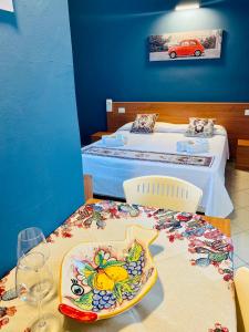 um quarto com duas camas e uma mesa com um prato em Angelo Apartments & Rooms em Trapani