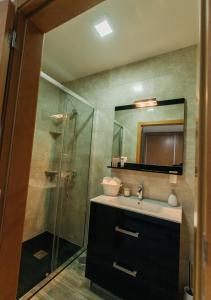 ein Badezimmer mit Waschbecken und Glasdusche in der Unterkunft Lamegos GuestHouse - Gerês in Terras de Bouro + 30 Fotos