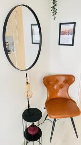 a mirror and a chair in a room at Kaari Home - Studio Apartment In the Heart of Tampere Next to Nokia Arena in Tampere