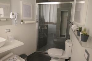 a white bathroom with a shower and a toilet at Casa Consoli in Catania