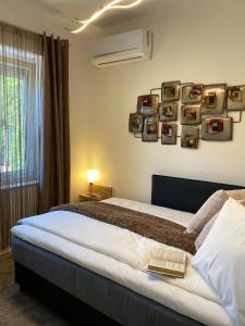 sypialnia z łóżkiem z ramą na ścianie w obiekcie Otium Wellness Apartmanház w mieście Balatonakarattya