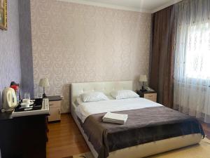 um quarto com uma cama grande e uma janela em Mini-Hotel Pulsar em Astana