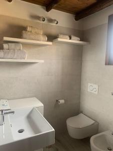 a bathroom with a sink and a toilet and towels at Panoramicissima in Costa Rei +38 photos