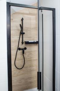 un bagno con doccia e porta in legno di Apartament Władysławowo a Władysławowo