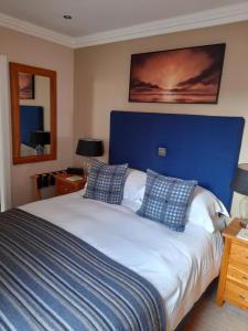 a bedroom with a large bed with a blue headboard at Langtrys in Blackpool