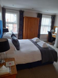 Habitación de hotel con cama grande y escritorio. en Langtrys, en Blackpool