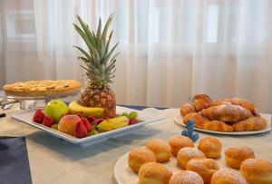 un tavolo ricoperto di piatti di frutta e prodotti da forno di Hotel Carnaby a Rimini