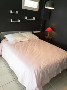 a bedroom with a white bed with a red lamp at Chambre meublée avec vue panoramique à Périgueux in Notre-Dame-de-Sanilhac