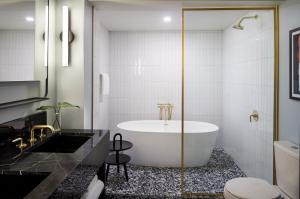 a bathroom with a white tub and a toilet at Kimpton Alton Hotel, an IHG Hotel in San Francisco