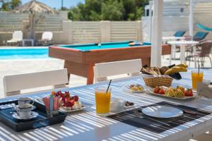 a table with a tray of food and drinks on it at Dahlia Apartments And Studios in Aliki