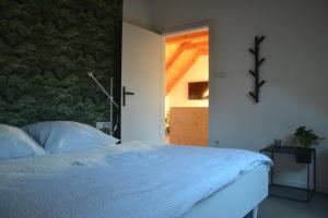 ein Schlafzimmer mit einem Bett mit einem Kreuz an der Wand in der Unterkunft Apartmán Červenice in Dlouhý