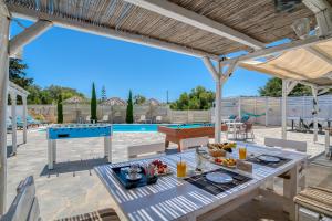 a patio with a table with food and a pool at Dahlia Apartments And Studios in Aliki