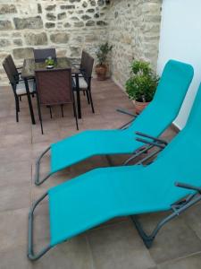 eine Terrasse mit blauen Stühlen und einem Tisch in der Unterkunft VTAR Casa del AOVE in Baeza
