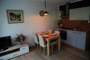 a kitchen with a table and chairs and a kitchen with white cabinets at Apartment Alpea in Bovec