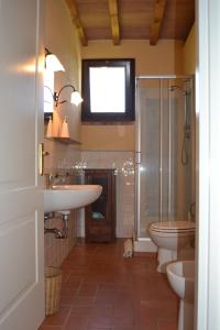 y baño con 2 lavabos, ducha y aseo. en Agriturismo Beveraggio Appartamenti, en Marina di Grosseto