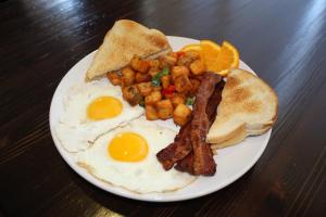 um prato de pequeno-almoço com ovos, bacon e torradas em Holiday Inn & Suites Peoria at Grand Prairie, an IHG Hotel em Peoria