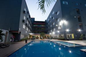 a swimming pool in front of a building at night at Golden Ville Hotel in Marabá