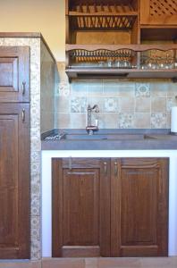 a kitchen with wooden cabinets and a sink at Agriturismo Podere Il Sorbo in Campagnatico