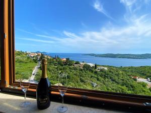 - une bouteille de vin et deux verres de vin devant une fenêtre dans l'établissement Sea View Suite, à Orašac