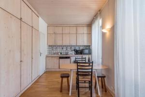 eine kleine Küche mit einem Holztisch und Stühlen in der Unterkunft Appartement du Mont - Résidence La Vardaffe - Welkeys in Chamonix-Mont-Blanc
