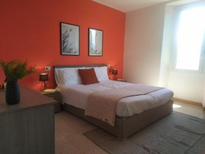プレージオにあるCasa Ginevraのベッドルーム1室(オレンジ色の壁のベッド1台付)