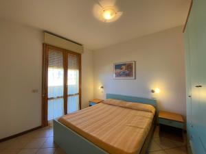 een slaapkamer met een bed en een raam bij Eden Appartamenti in Marina di Grosseto