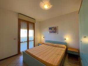 a bedroom with a bed and a window at Eden Appartamenti in Marina di Grosseto