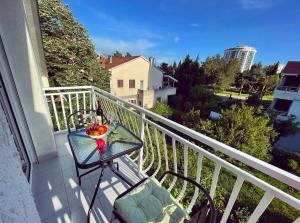 a glass table on a balcony with a bowl of fruit at Apartmani Agi in Budva
