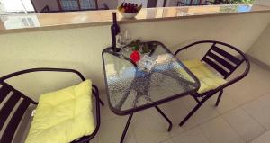 a glass table and a chair in a room at Apartmani Agi in Budva