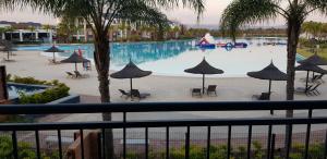 a view of a swimming pool with umbrellas at Blyde Lagoon View Apartment in Pretoria