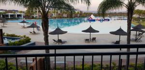 - Vistas a una piscina con sombrillas en Blyde Lagoon View Apartment, en Pretoria