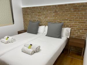 1 dormitorio con 2 camas y pared de ladrillo en Oktheway Pedro Saco Street, en Sarria