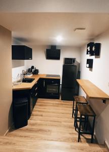 a kitchen with a black refrigerator and a wooden floor at Spa privatif by XELA in Auxerre