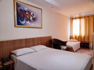 um quarto de hotel com duas camas e uma cadeira em San Francisco Plazza em São Paulo