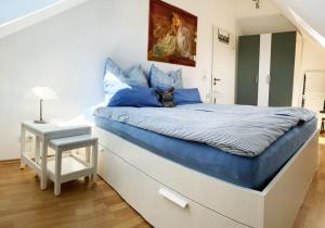 een slaapkamer met een groot bed met blauwe kussens bij Antje's Ferienwohnung Rastede in Rastede