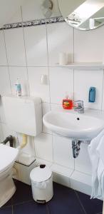 een witte badkamer met een wastafel en een toilet bij Antje's Ferienwohnung Rastede in Rastede