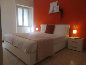 a bedroom with a large bed with an orange wall at Casa del Fra' in Plesio