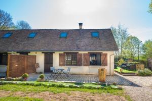 ein Haus mit einem Dach und einer Terrasse in der Unterkunft GITES du BOIS des PERRUCHES in Saint-Vincent-des-Bois